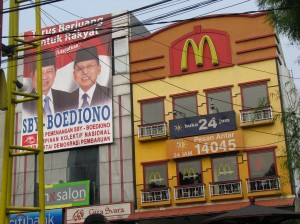 A campaign banner for the current President of Indonesia on a building next to McDonalds